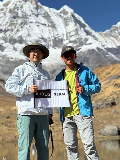 Two people showing kudos nepal on paper