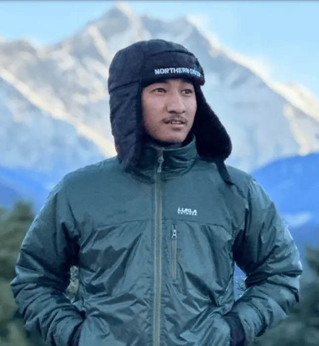 Young man standing on mountain background