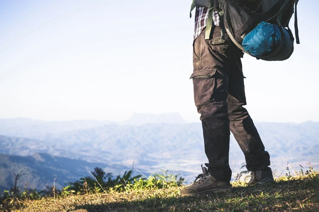 tourist-from-mountain-top-sun-rays-man-wear-big-backpack-against-sun-light